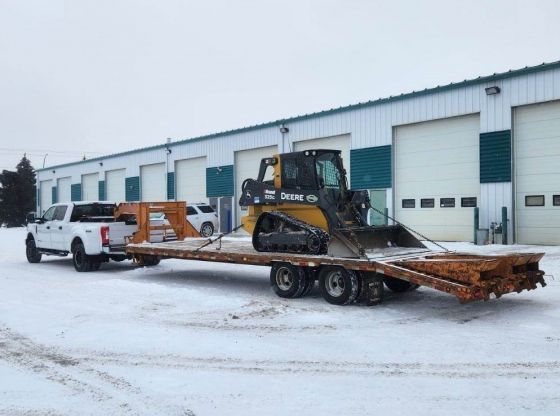 John Deere Skid Steer, model 325G on trailer